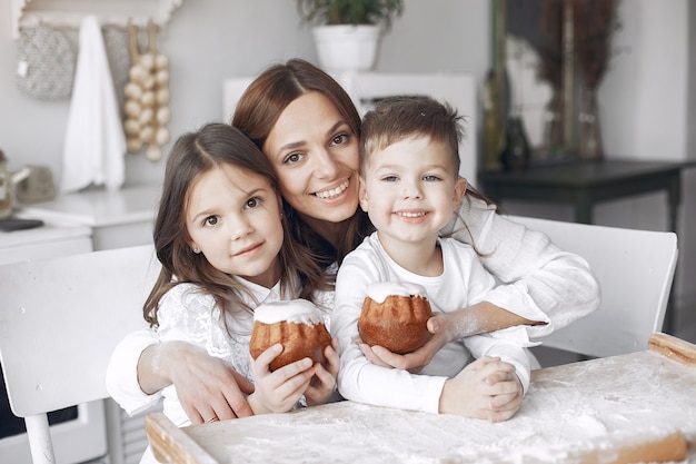 Familie sitzt in einer Küche und kocht den Teig für Kuchen