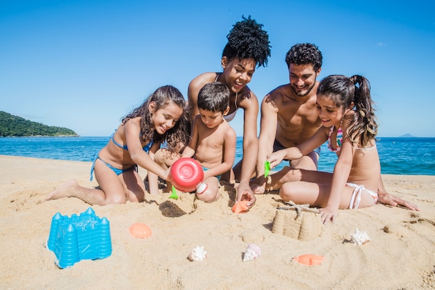 Familie spielt mit dem Sand