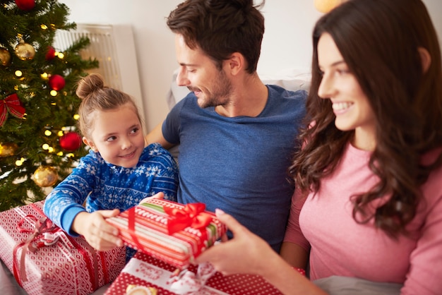 Familie teilt die Weihnachtsgeschenke im Bett