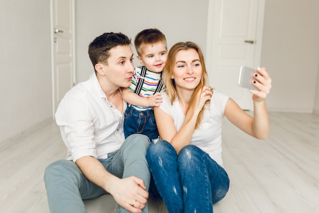 Familienbild von zwei jungen Eltern, die mit ihrem Jungenkind spielen