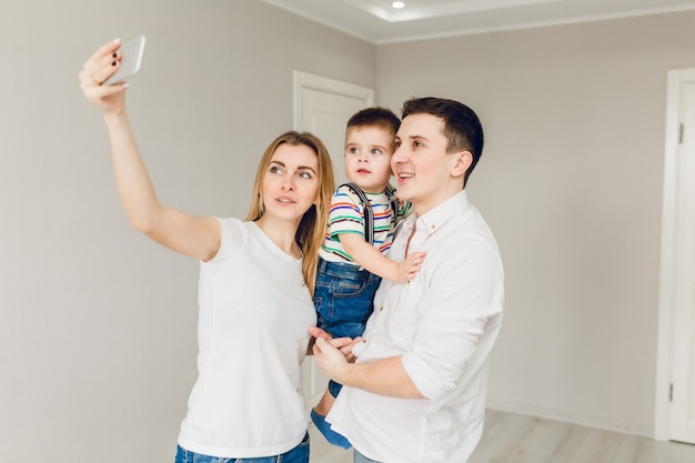 Familienbild von zwei jungen Eltern, die mit ihrem Jungenkind spielen