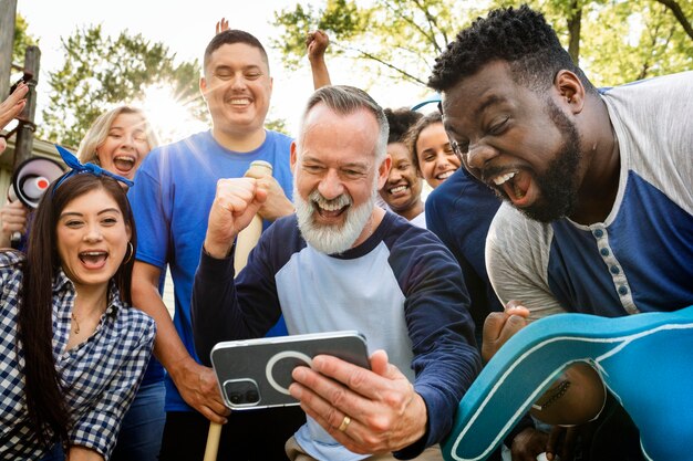 Fans sehen ihrem Team zu, wie es das Spiel auf einem Mobiltelefon gewinnt