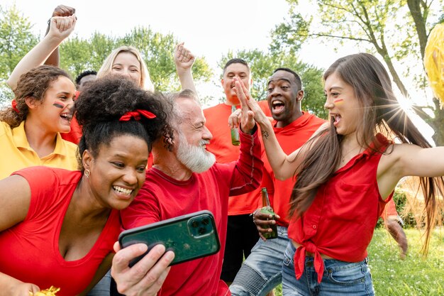 Fans sehen ihrem Team zu, wie es das Spiel auf einem Mobiltelefon gewinnt