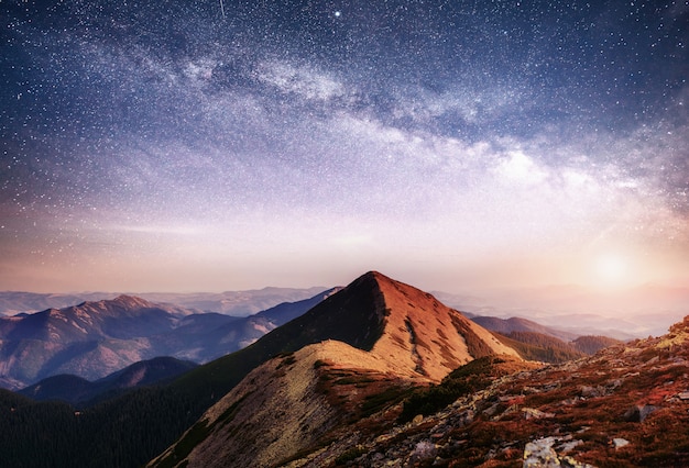 Fantastische Landschaft in den Bergen der Ukraine. Lebendiger Nachthimmel mit Sternen und Nebel und Galaxie.