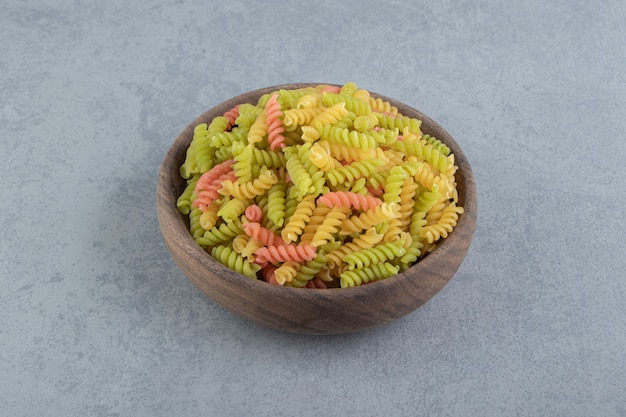 Farbige Fusilli-Nudeln in Holzschale.