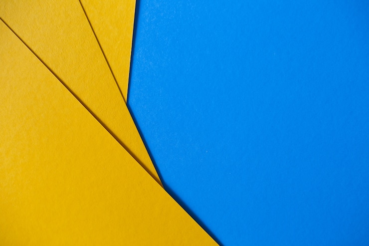 Kostenlose Foto farbiger geometrischer blauer und gelber papierbeschaffenheitshintergrund