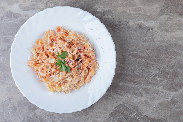 Farfalle-Nudeln mit Bolognese auf der Schüssel, auf dem Marmor.