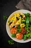 Kostenloses Foto farfalle pasta hartweizen mit gebackenen fleischbällchen aus hähnchenfilet in tomatensauce und salat in einer schüssel.