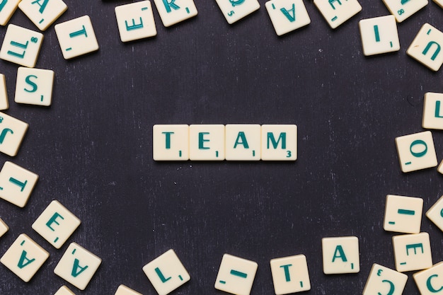 Fassen Sie Team in den Scrabble-Buchstaben über schwarzem Hintergrund ab
