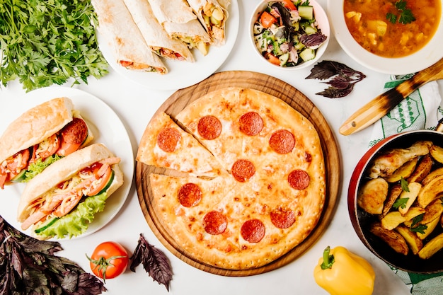 Fast-Food-Auswahl, darunter Pizza, Sandwiches, Shaurma, Salat, gegrillte Kartoffeln und Suppe.