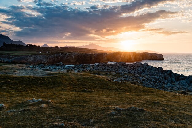 Faszinierende Aussicht auf den Strand, umgeben von felsigen Bergen während des Sonnenuntergangs