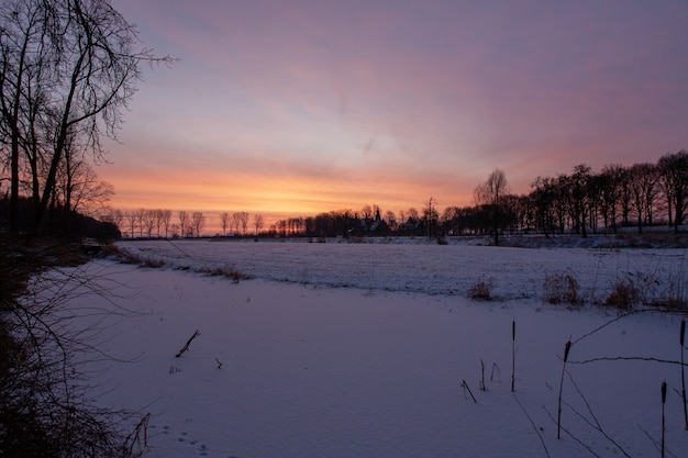 Faszinierender Sonnenuntergang nahe dem historischen Doorwerth Schloss während des Winters in Holland