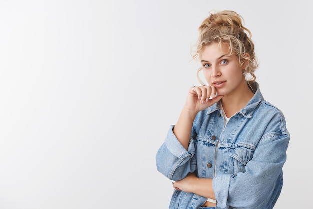 Fasziniert gutaussehende skandinavische blonde lockige Frau blaue Augen schauende Kamera interessiert zuhören guter Rat Vorschlag stehend nachdenklich weißer Hintergrund erwägen, Entscheidung zu treffen