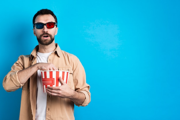 Kostenloses Foto faszinierter mann mit popcorneimer