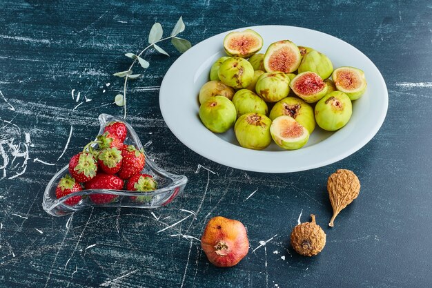 Kostenloses Foto feigen in einem weißen teller mit erdbeeren in einer glasschale.