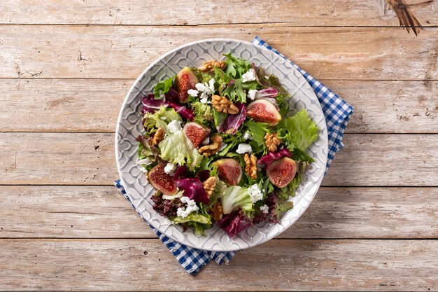 Feigensalat mit Käse und Walnüssen auf Holztisch.