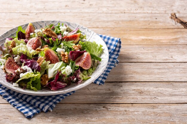 Feigensalat mit Käse und Walnüssen auf Holztisch.