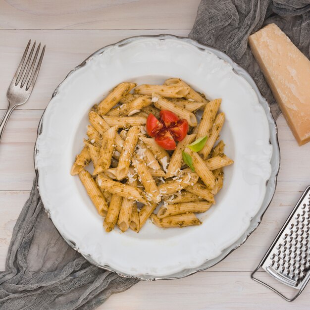 Feinschmeckerische geschmackvolle italienische penne Teigwaren mit Tomate und Kräutern auf einer weißen Platte