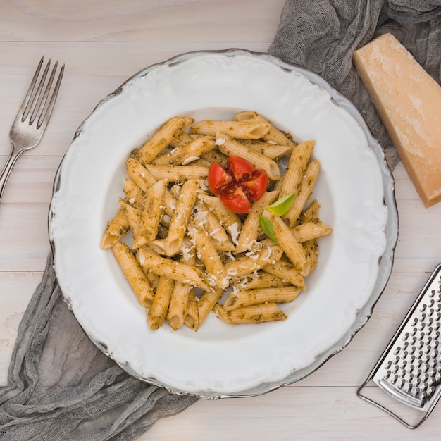 Feinschmeckerische geschmackvolle italienische penne Teigwaren mit Tomate und Kräutern auf einer weißen Platte