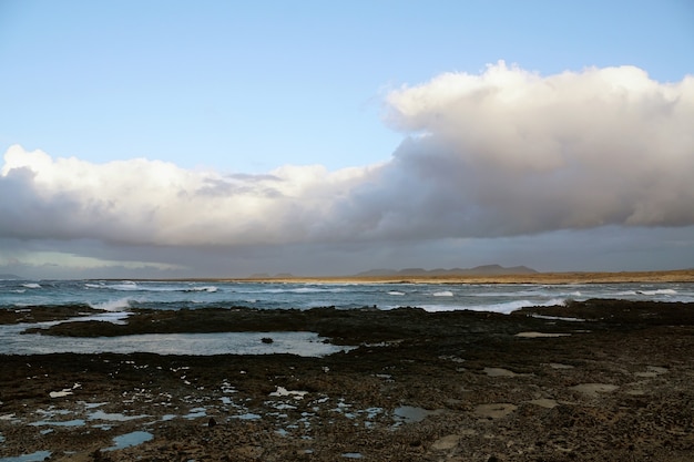 Kostenloses Foto felsiger strand und bewölktes wetter