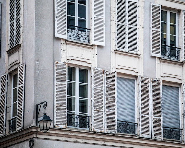 Fenster eines alten Wohnhauses unter dem Sonnenlicht tagsüber in Paris, Frankreich