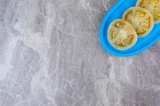 Fermentierte Tomatenscheiben auf blauem Teller