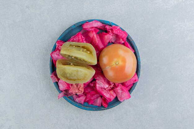 Fermentierter Rotkohl, ganze und in Scheiben geschnittene Tomaten in einer Holzplatte