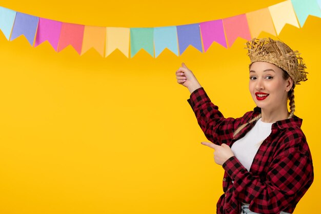 Festa junina blondes süßes mädchen im brasilianischen festival des strohhutes mit den bunten fahnen glücklich