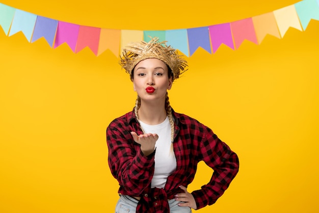 Festa junina blondes süßes mädchen im brasilianischen festival des strohhutes mit den bunten flaggen, die küsse senden