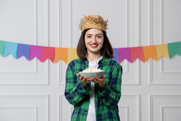 Festa junina junges hübsches mädchen mit strohhut, der brasilianische party mit popcorn feiert