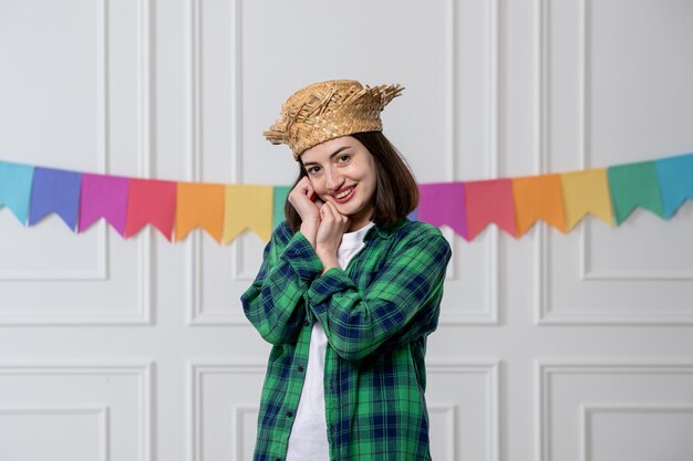 Festa junina junges hübsches mädchen mit strohhut, der die brasilianische party feiert und süß lächelt