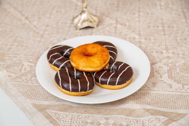 Festliche donuts mit schokolade in einem teller auf dem tisch. horizontales foto