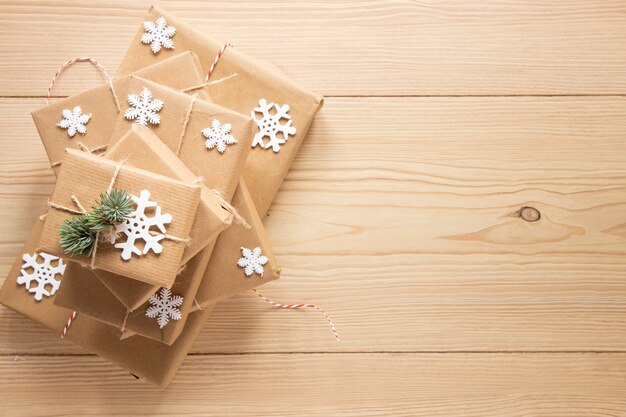 Festliche Geschenke mit Schneeflocken auf hölzernem Hintergrund