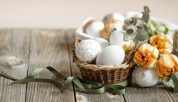 Festliche Komposition für die Osterferien mit frischen Blumen und Eiern hautnah. Osterdekor-Konzept.