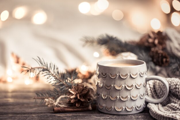 Festliche Wand mit Tasse auf Holzwand mit Lichtern.