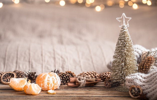 Festliche Weihnachts gemütliche Atmosphäre mit Wohnkultur und Mandarinen auf einem hölzernen Hintergrund, Wohnkomfortkonzept