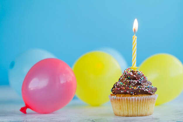 Festlicher kleiner Kuchen und bunte Luftballons