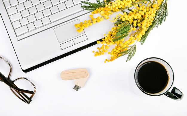 festlicher Satz des Frühlinges mit Blumen und ein Laptop auf einem weißen Hintergrund