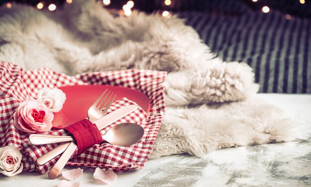 Festliches Abendessen zum Valentinstag auf einem hölzernen Hintergrundbesteck