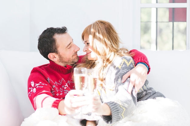 Kostenloses Foto festliches glückliches paar mit champagner auf sofa