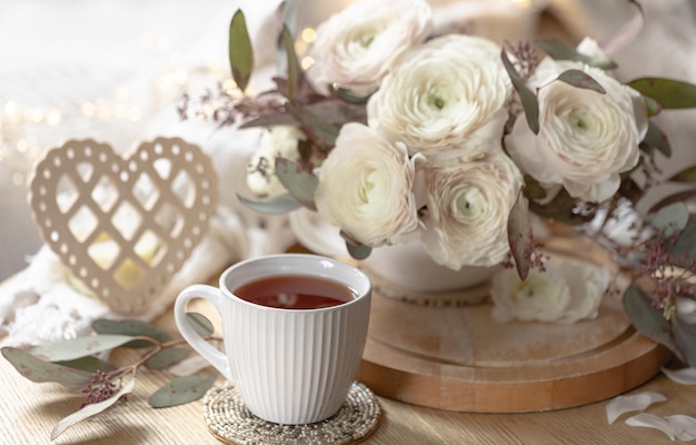 Kostenloses Foto festliches stillleben mit blumen, tasse tee und dekorativem herzen