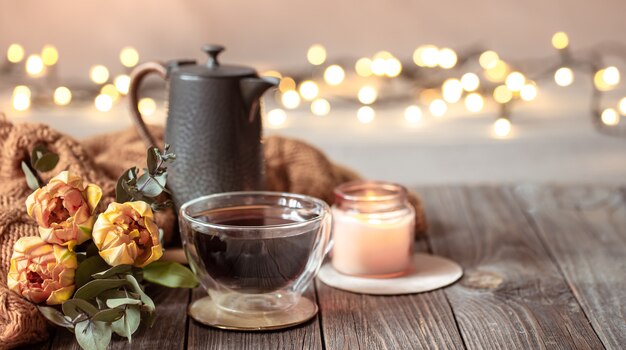 Festliches Zuhause Stillleben mit einer Tasse Getränk, Blumen und Dekor Details auf einem unscharfen Hintergrund mit Bokeh.