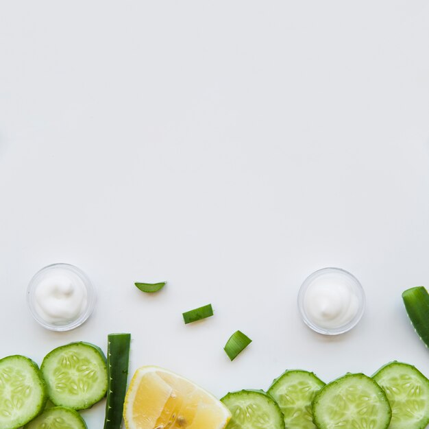Feuchtigkeitscremebehälter; Aloe Vera; Zitronen- und Gurkenscheiben auf weißem Hintergrund
