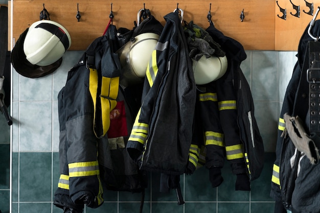 Kostenloses Foto feuerwehranzüge hängen von der wand am bahnhof