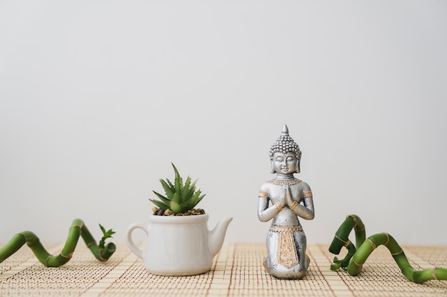 Figur von buddha und topf mit dekorativem bambus