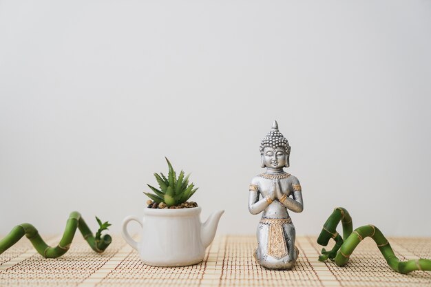 Figur von Buddha und Topf mit dekorativem Bambus