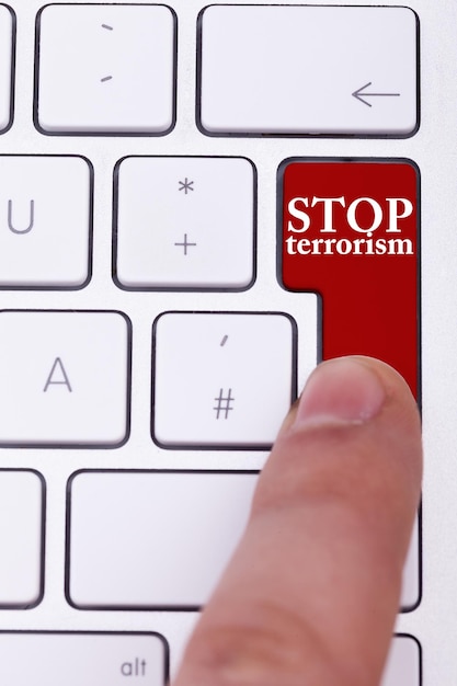 Finger, der auf die Schaltfläche "Terrorismus stoppen" auf der Tastatur drückt. Stoppt die Verbrechen gegen Zivilisten