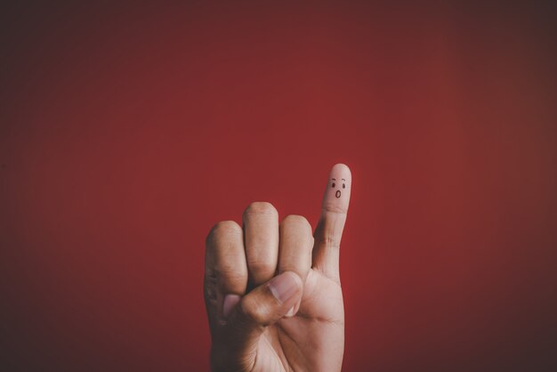 Finger mit Gefühl auf rotem Hintergrund