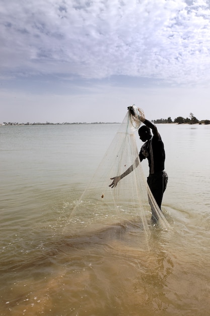 Fischer mit Netz am Fluss