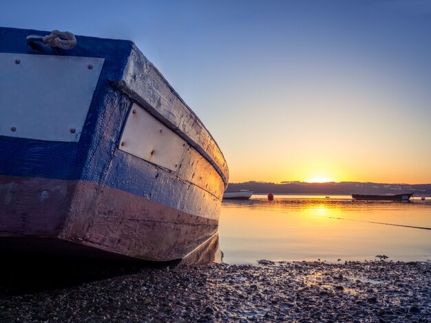 Fischerboot am Fluss mit dem schönen Sonnenuntergang